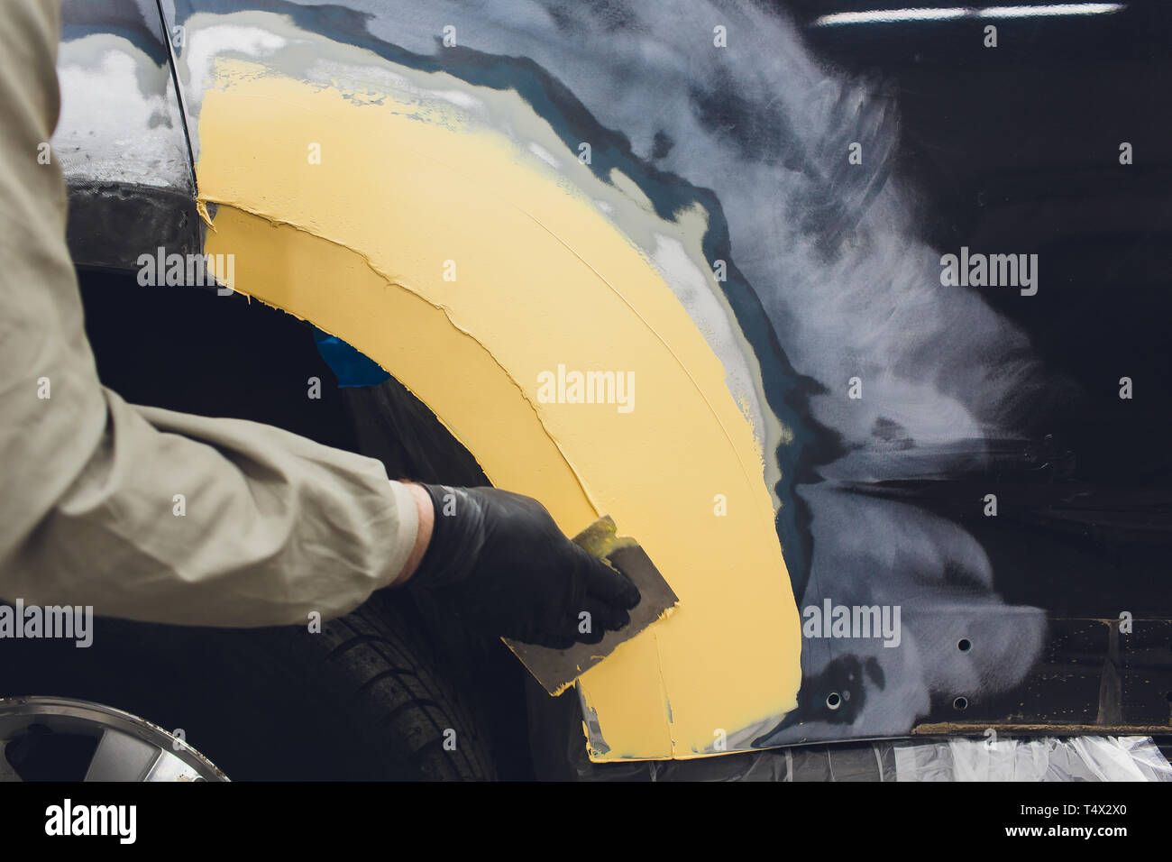 Vorbereitung für die Lackierung eines Autos mit schmirgel Absender ein Service Techniker, Nivellierung, bevor Sie eine Grundierung nach der Beschädigung auf einen Teil des Bsb Stockfoto