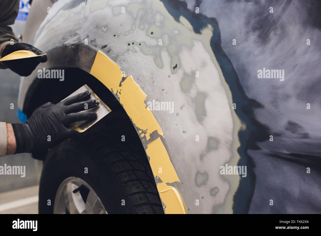 Vorbereitung für die Lackierung eines Autos mit schmirgel Absender ein Service Techniker, Nivellierung, bevor Sie eine Grundierung nach der Beschädigung auf einen Teil des Bsb Stockfoto
