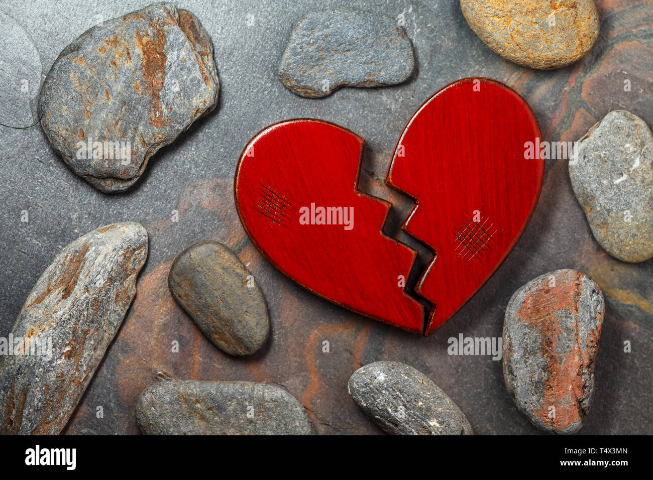 Gebrochene Holz- rotes Herz auf Hintergrund. Stockfoto