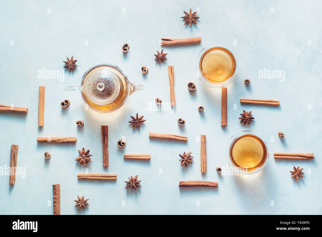Zimt und Anis Muster mit Teekanne und Kaffee Schalen auf einem weißen Holz- Hintergrund mit kopieren. Heißes Getränk creative Flach. Stockfoto