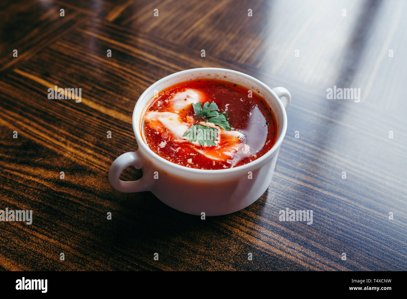 Weihnachten Rote-Bete-Suppe, mit kleinen Knödel mit Pilz Füllung in eine keramische Schüssel auf einem Holztisch Borscht. Traditionelle Weihnachtsabend Gericht in Pol Stockfoto