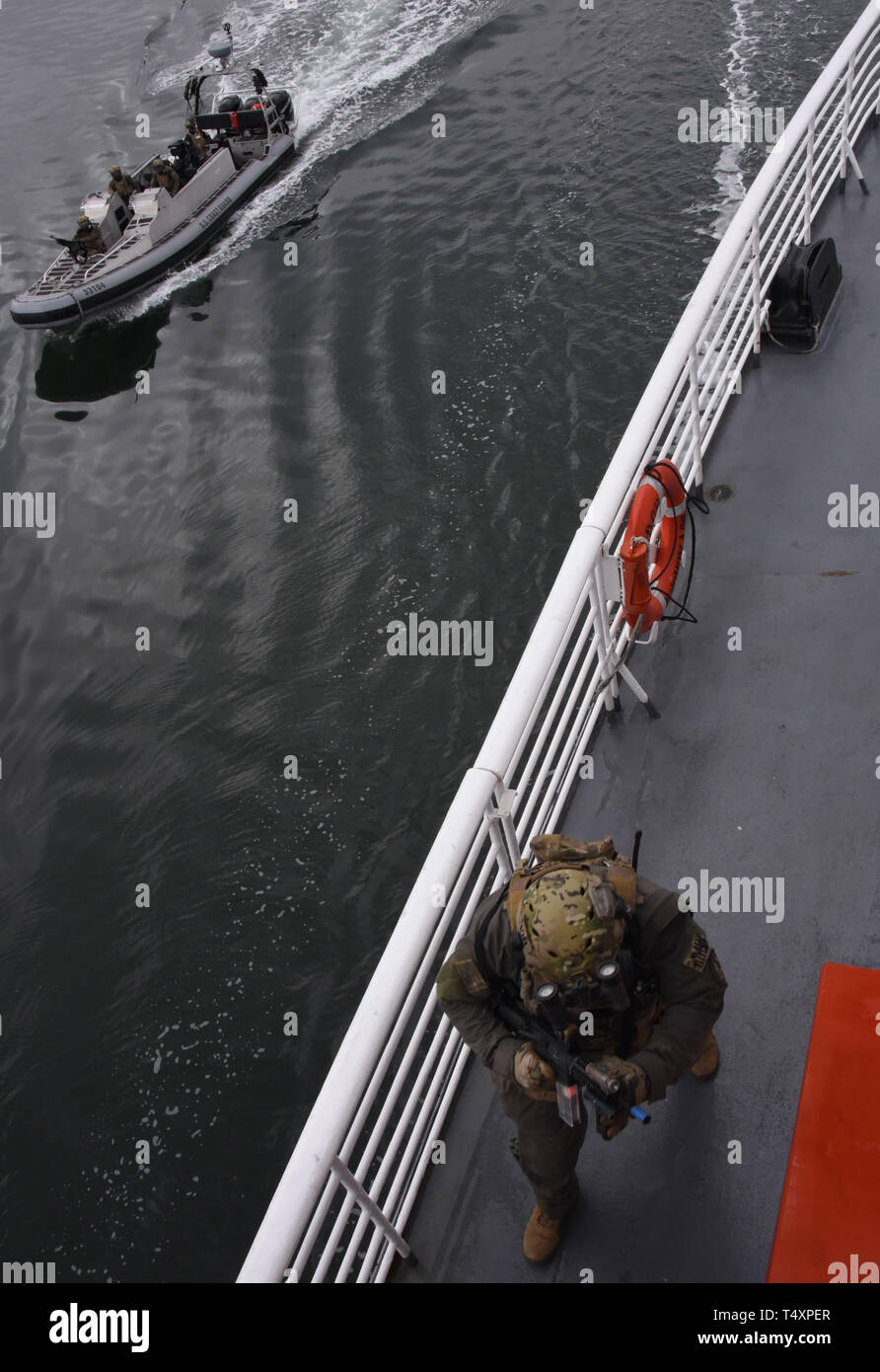 Ein Mitglied der Küstenwache Maritime Security Response Team West Trains für eine simulierte terroristische Bedrohung an Bord der Aurora, um während des Transports nach Whittier, Alaska, 10. April 2019. Team Mitglieder Zug in eine Vielzahl von Klimazonen und Bedingungen von Fähigkeiten, um Terrorakte zu verhindern und die Öffentlichkeit sicher halten. U.S. Coast Guard Foto von Petty Officer 3. Klasse Lauren Dean. Stockfoto