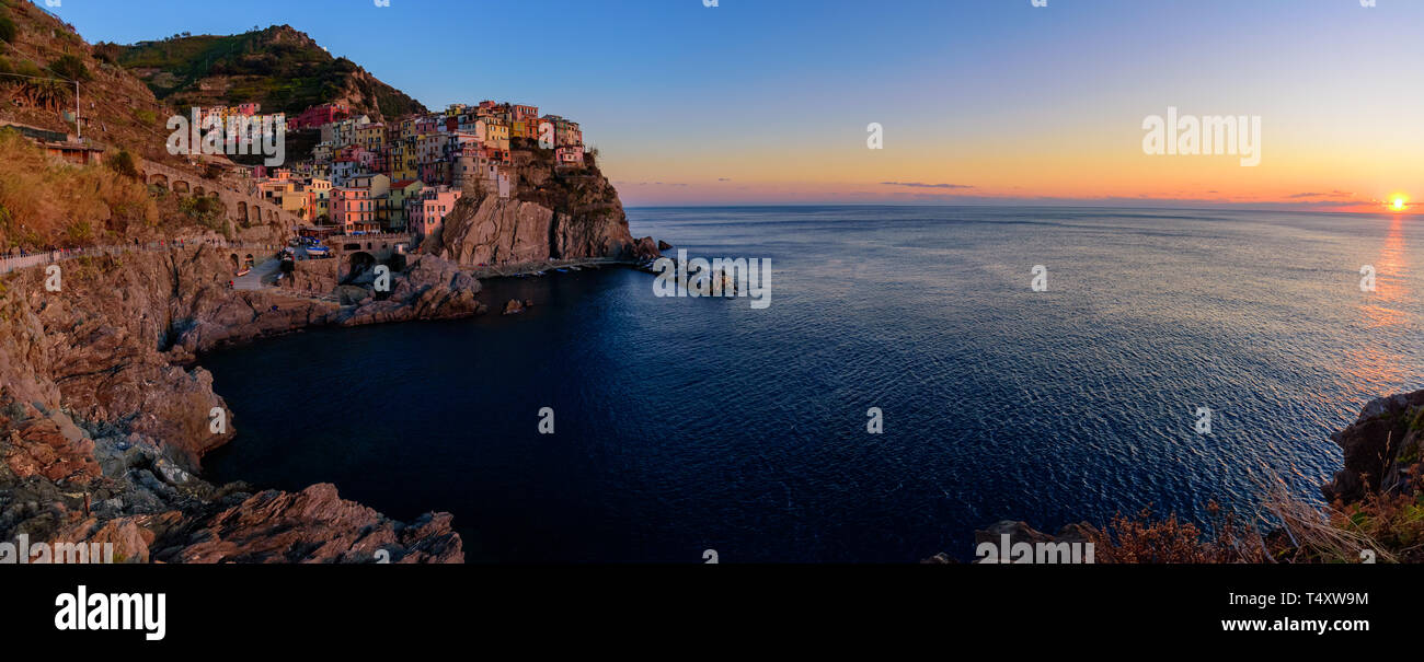 Panorama der Sonnenuntergang von Manarola, einer der fünf mediterranen Dörfer der Cinque Terre, Italien, bekannt für seine bunten Häuser und den Hafen. Stockfoto