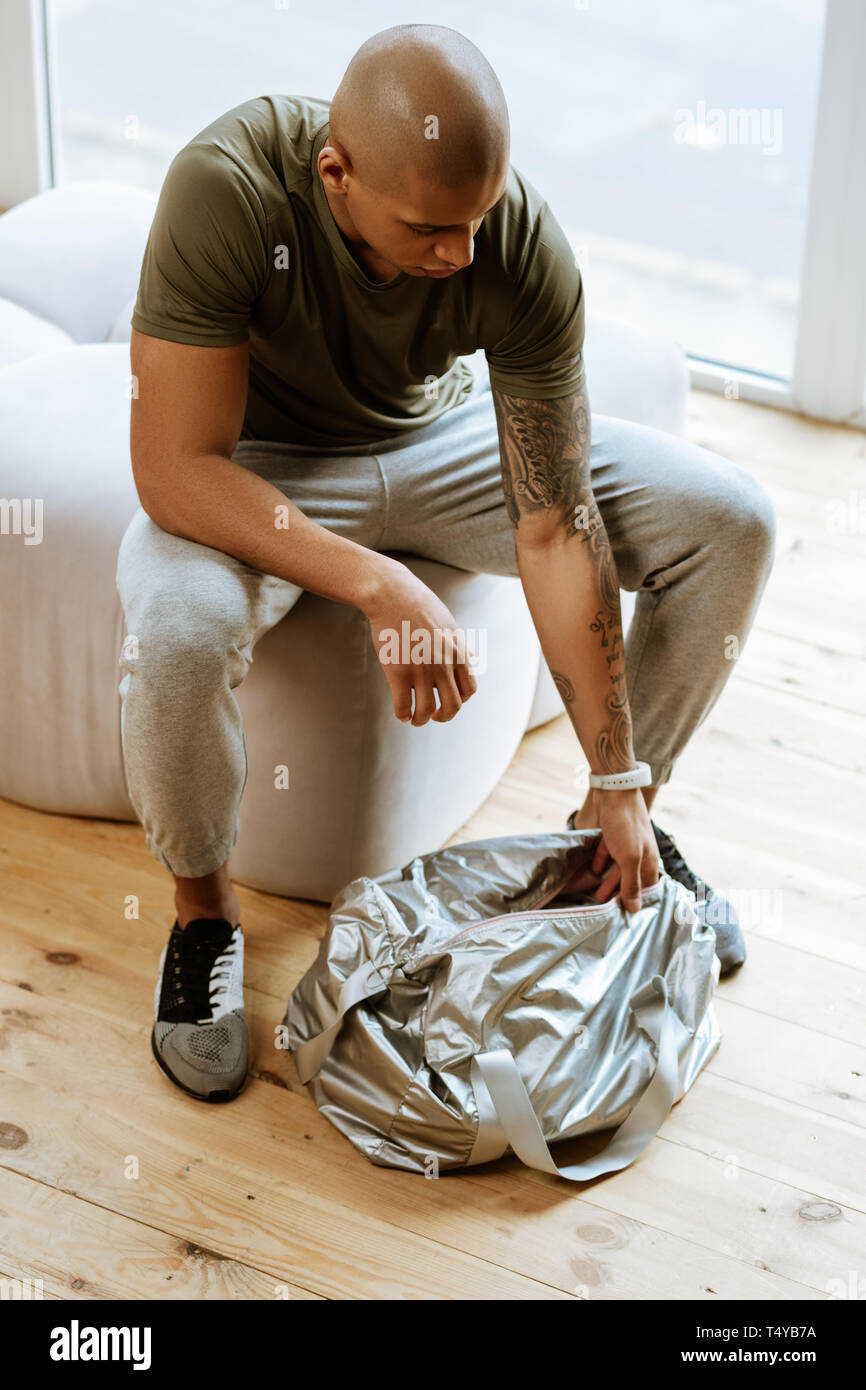 Sportsman auspacken seinen Sport Tasche nach Hause kommen aus Fitnessraum Stockfoto