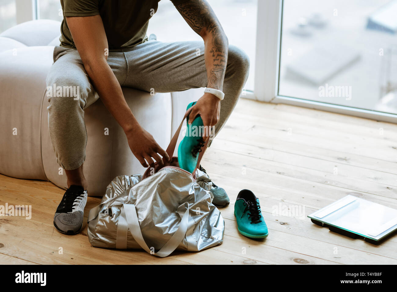 Dunkelhäutige Sportler mit tattoo Sneakers in die Tasche Stockfoto