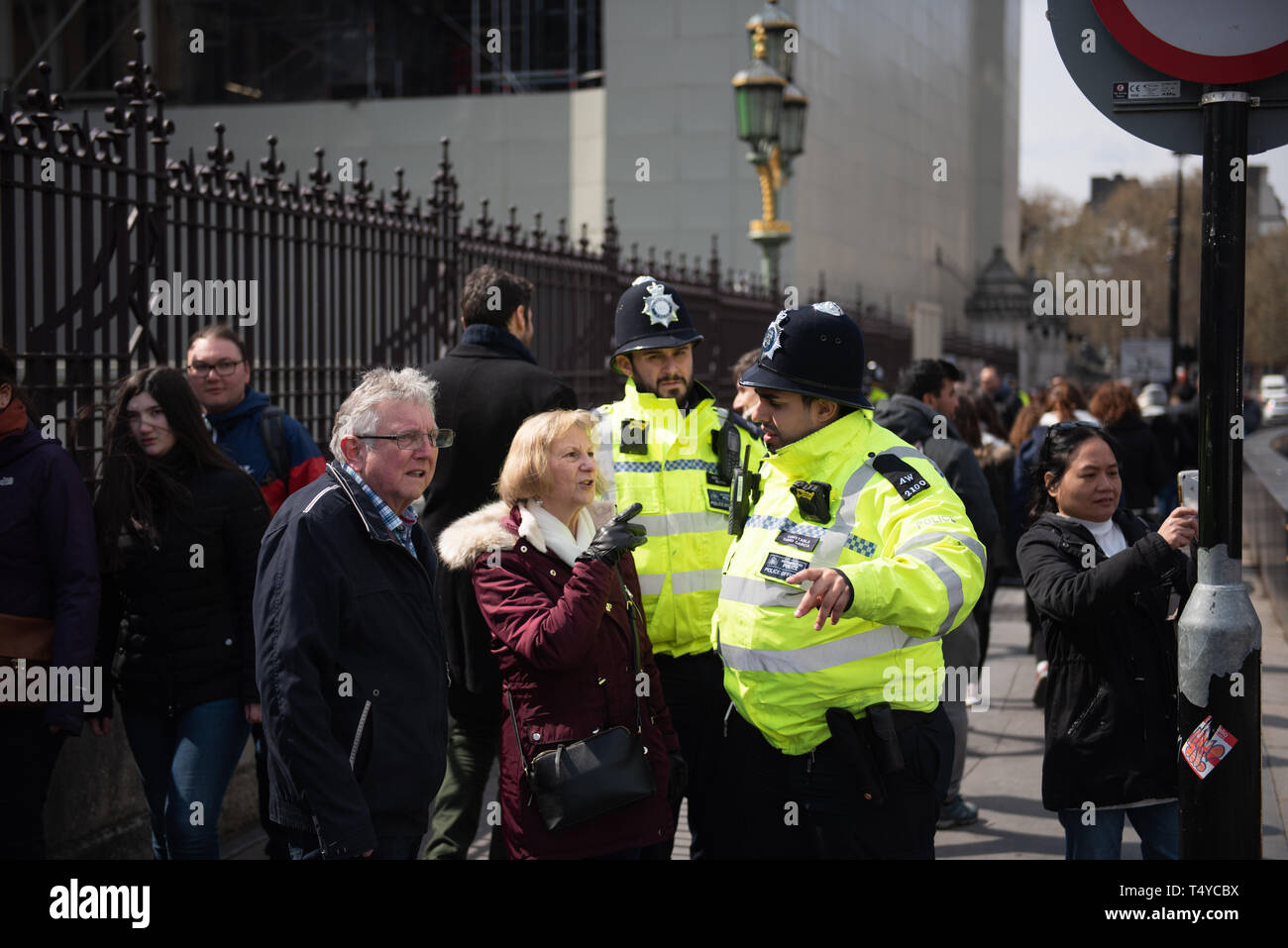 London, Großbritannien, 13. April 2019: - Zwei Polizisten Leuten helfen außerhalb Westminster Parlament des Vereinigten Königreichs Stockfoto