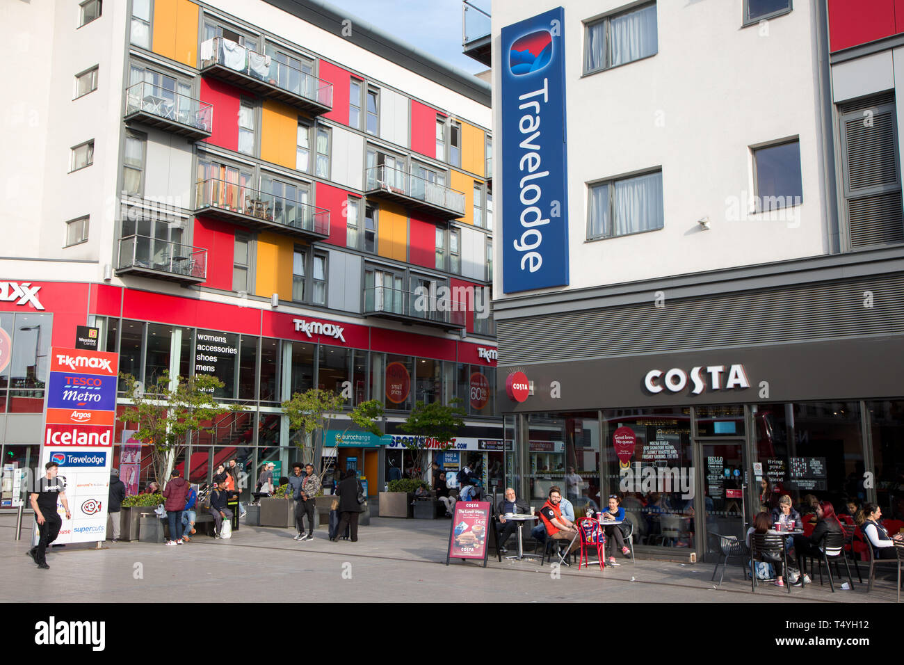 Kunden von Costa Kaffee konsumieren Getränke im Freien in der Sonne in einem modernen Einkaufs- und Wohnungsbau, Wembley Central Stockfoto