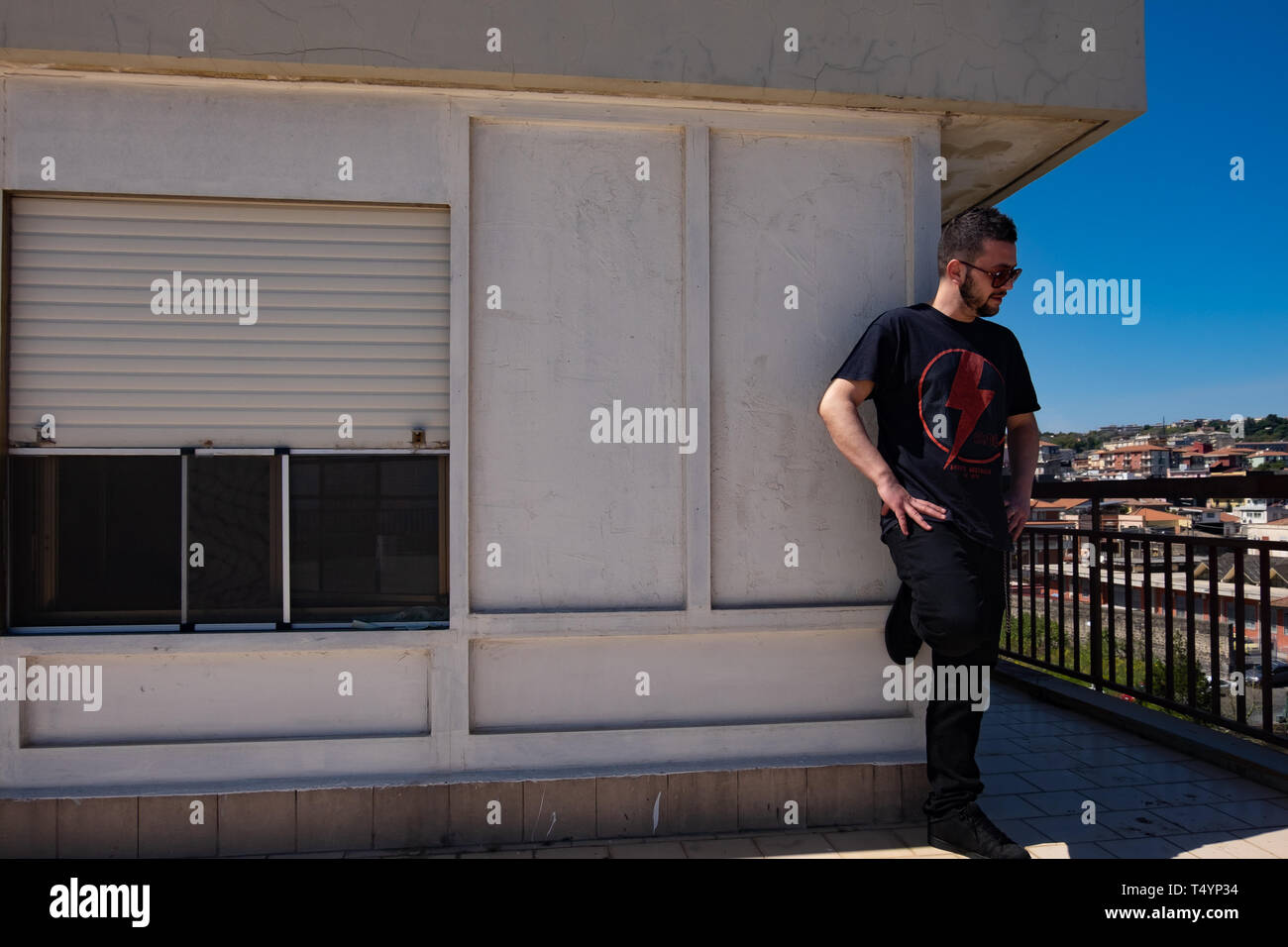 Sizilien, Italien - 29. Februar 2016: Unbekannte junge Mann stand auf dem Balkon seines Hauses in Catania. Stockfoto