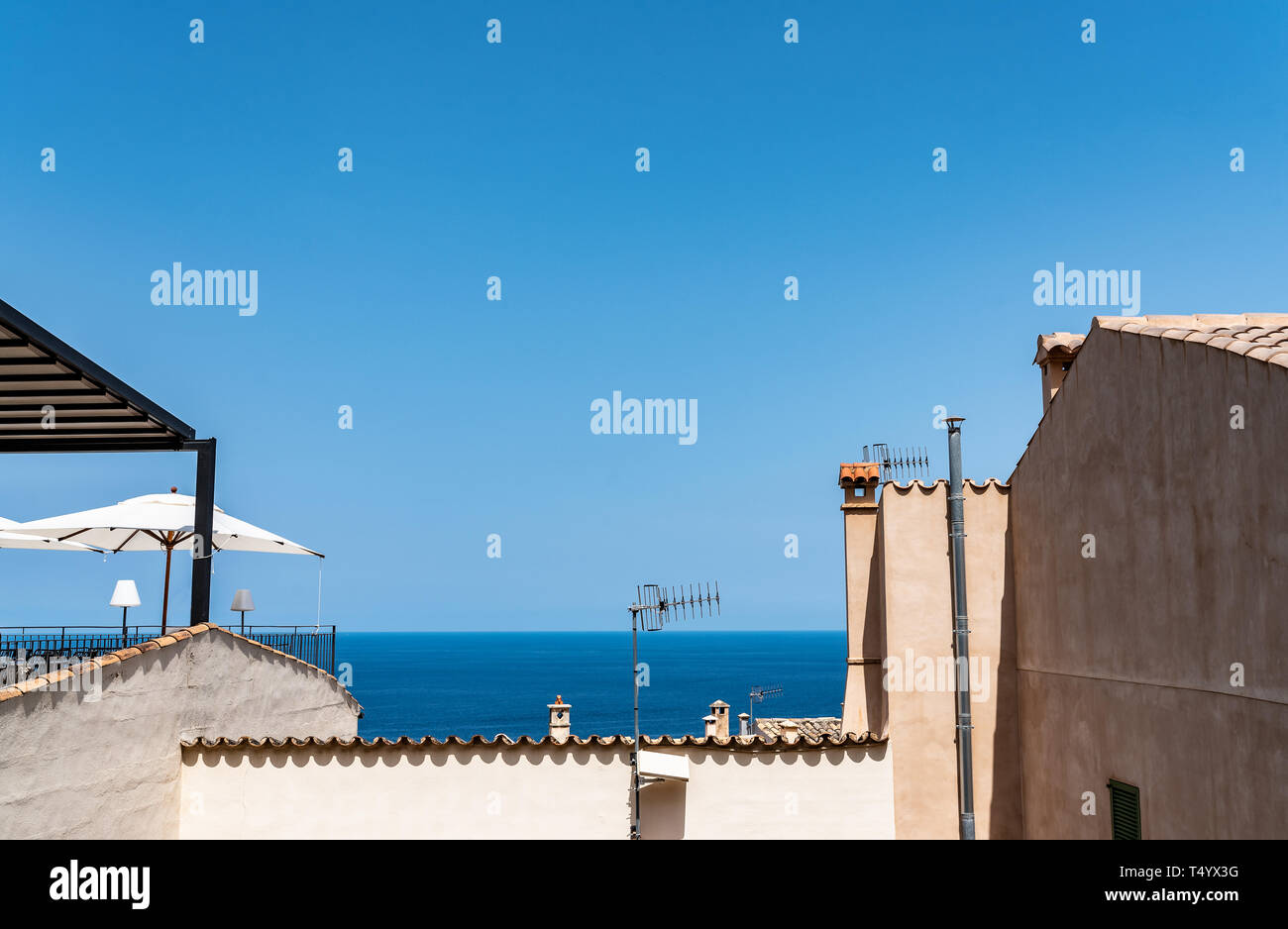 Strahlend blauer Himmel und Ozean über den Dächern der typische alte Häuser im mediterranen Dorf Stockfoto