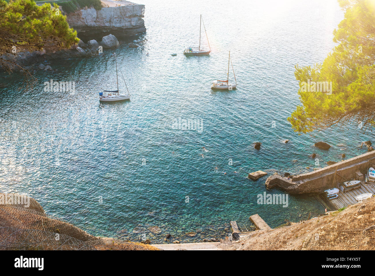 Hohe ange Blick auf Segelboote und Menschen schwimmen im idyllischen Bucht auf der Insel Mallorca am sonnigen Sommertag Stockfoto