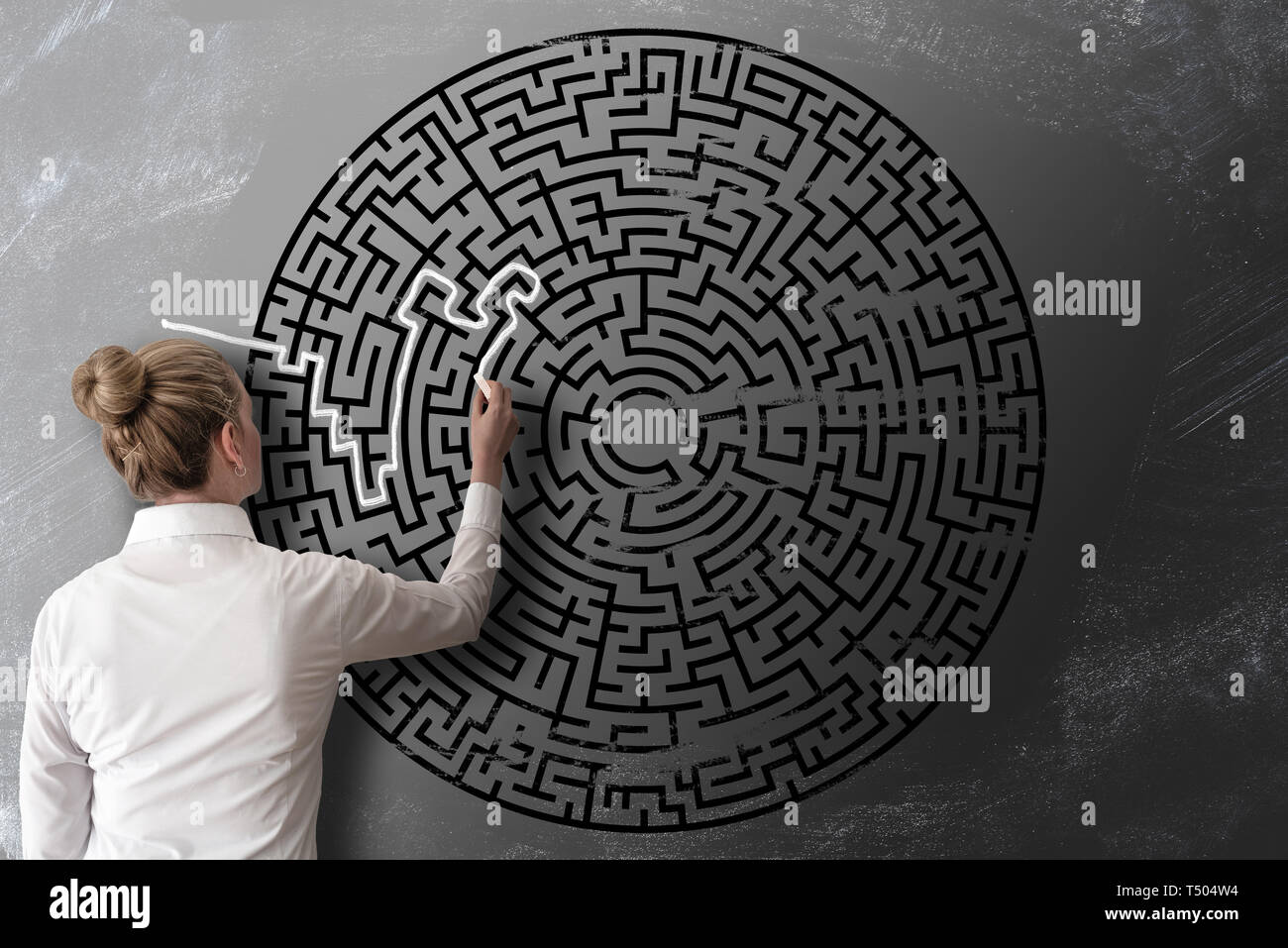 Lesen Sie mehr Blick auf die Frau, die versucht, durch Kreidezeichnung von Labyrinth auf blackboard Herausforderung Konzept zu finden Stockfoto