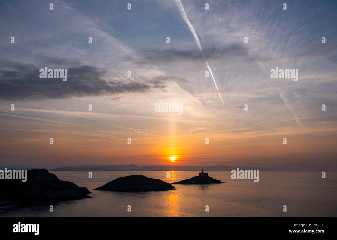 Swansea, Großbritannien. 20 Apr, 2019. Die Sonne über dem markanten Mumbles Landspitze und Leuchtturm in der Nähe von Swansea heute am Anfang einer warmen Ostersamstag. Credit: Phil Rees/Alamy leben Nachrichten Stockfoto