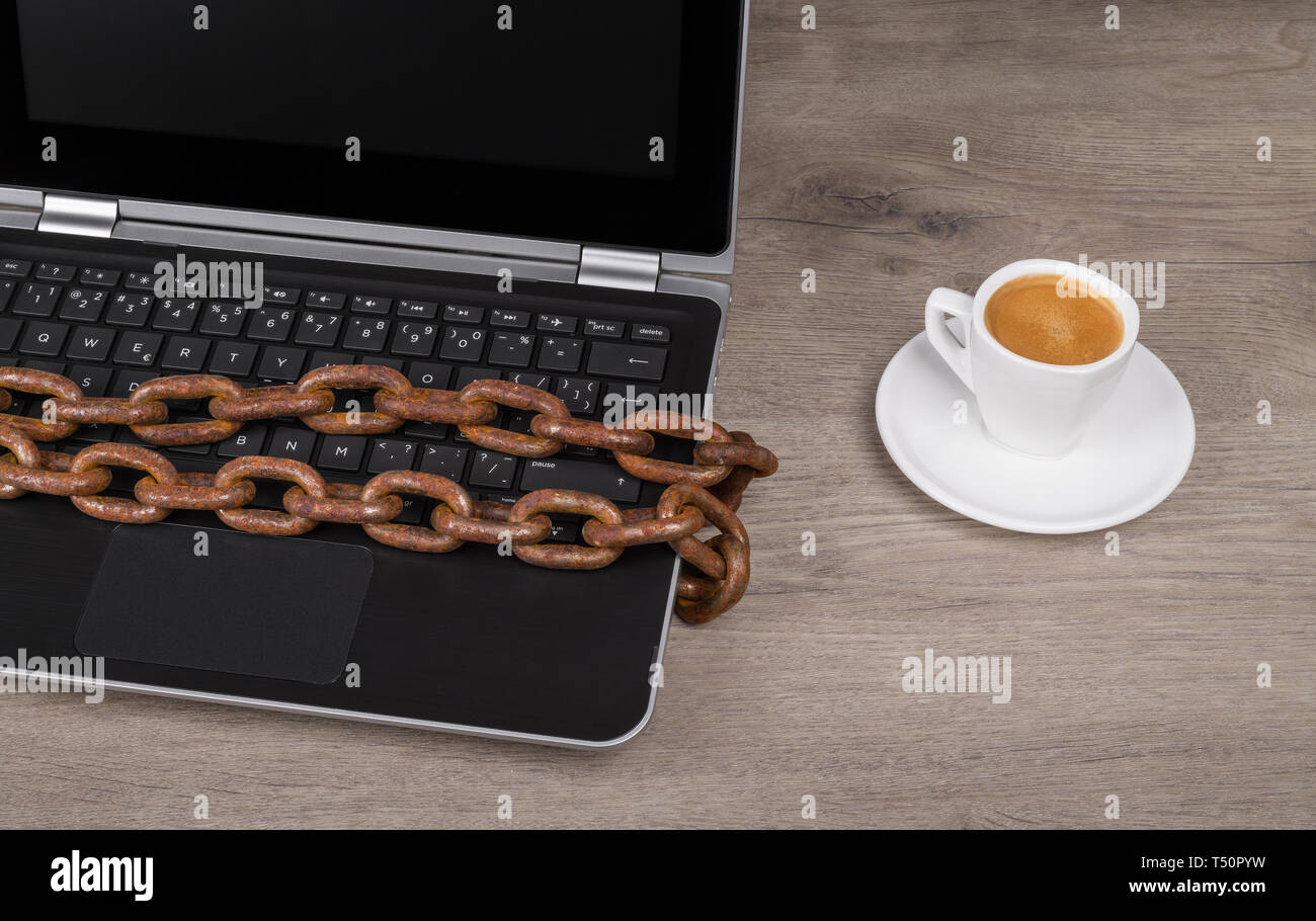 Datenschutz. Rostige Kette. Laptop Tastatur detail. Kaffee. Leere digitale Anzeige. Tasse und Untertasse. Holz- büro Schreibtisch. Zensiert internet, Spionage. Stockfoto