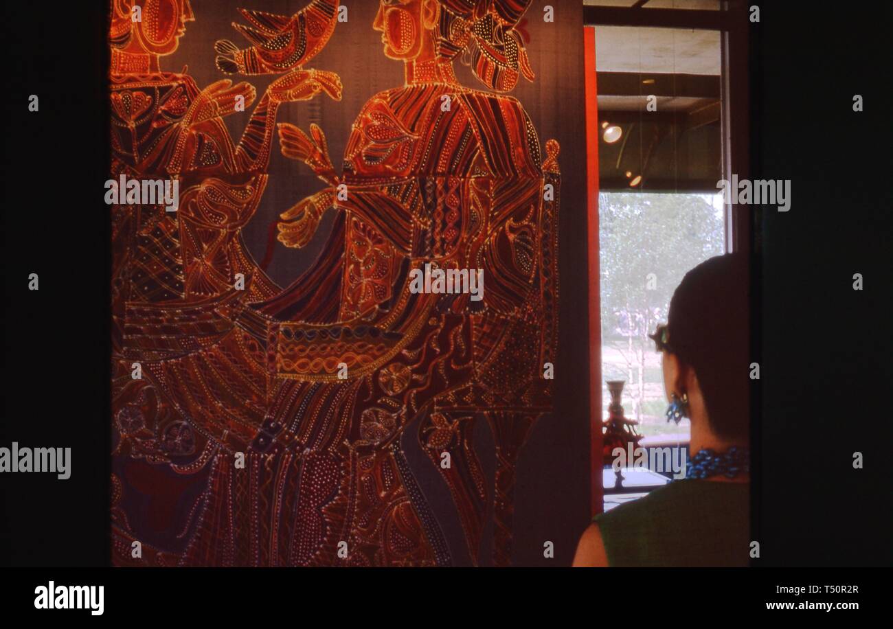 Eine Frau, die aus der Rückseite, Blicke auf einer großen Skala figürlichen Kunstwerke, wahrscheinlich eine Batik, an einer Wand im Rahmen einer Anzeige mit dem New York Weltmesse, Flushing Meadows Park, Queens, New York, Juni 1964 verbundenen montiert. () Stockfoto