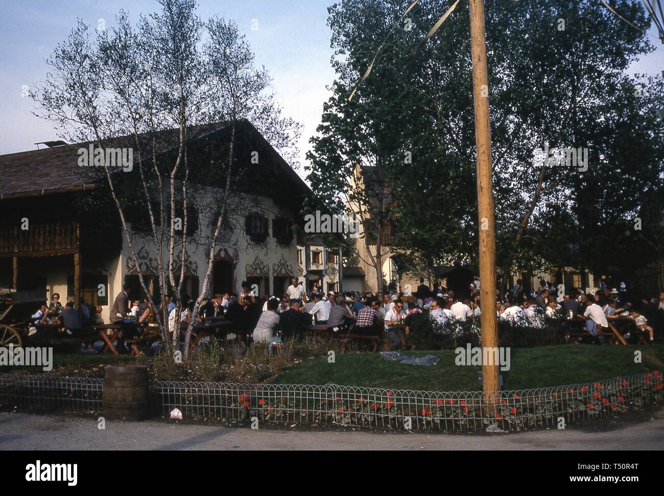 Eine Masse von Menschen in den Zeilen von Picknick Tische draußen sitzen, im Löwenbräu des Bayerischen-themed Biergarten, an einem sonnigen Tag, New York Weltmesse, Flushing Meadows Park, Queens, New York, Juni 1964. () Stockfoto