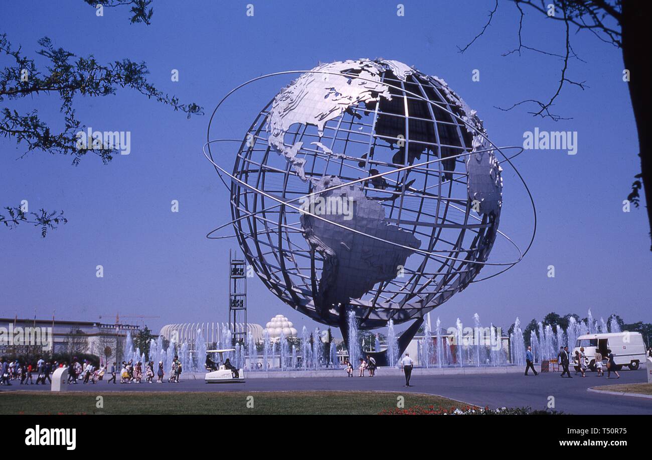 Weite Einstellung von Menschen zu Fuß auf einem Gehsteig in der Nähe der Unisphere, an einem sonnigen Tag, in New York World's Fair, Flushing Meadows Park, Queens, New York, Juni 1964. () Stockfoto