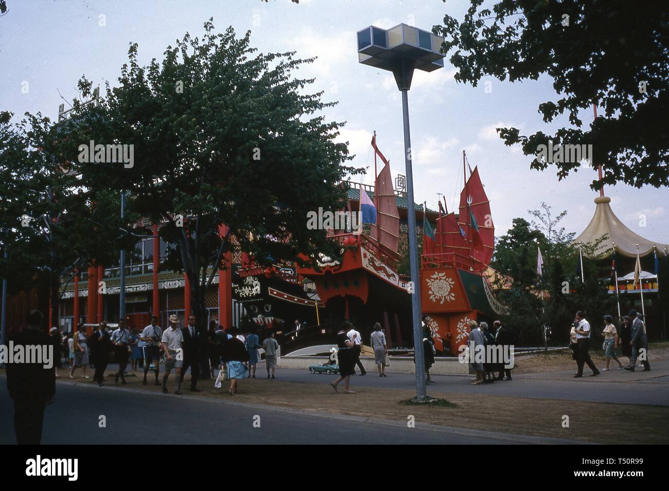 Menschen zu Fuß auf einem Bürgersteig in der Nähe von mock Chinesische Dschunken, die Teil des Hong Kong Pavilion während der Messe die New Yorker Welt gebildet, Flushing Meadows Park, Queens, NY, Juni 1964. () Stockfoto