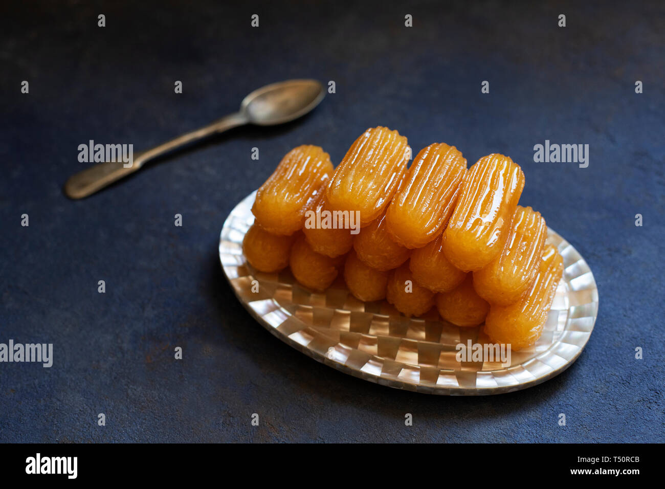 Traditionelle Dessert tulumba genannt. Türkische Küche. Balkan Küche. Levantinischen Küche. Auf einem blauen Hintergrund, serviert auf einem Vintage orientalische Platte Stockfoto