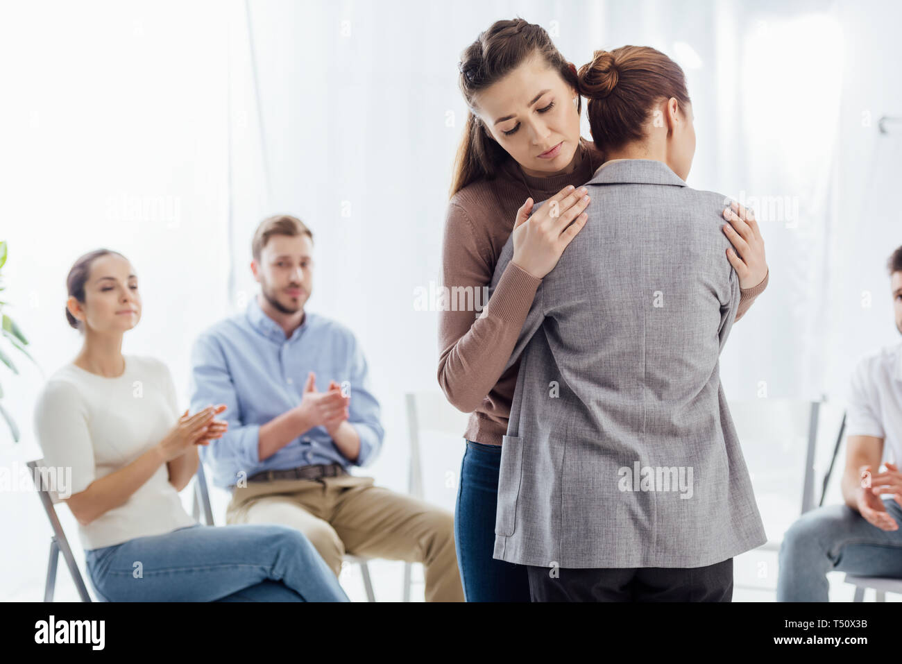 Selektiver Fokus von Frauen umarmen während der Gruppe Therapie Sitzung Stockfoto