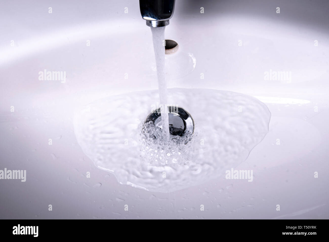 Fließendes Wasser in der Spüle mit Stecker und Wasser Stockfoto