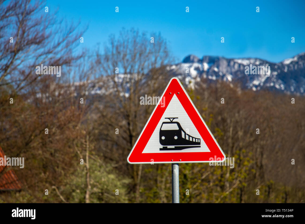 Warnschild Bahnübergang in Bayern, Deutschland mit Berg Hintergrund Stockfoto