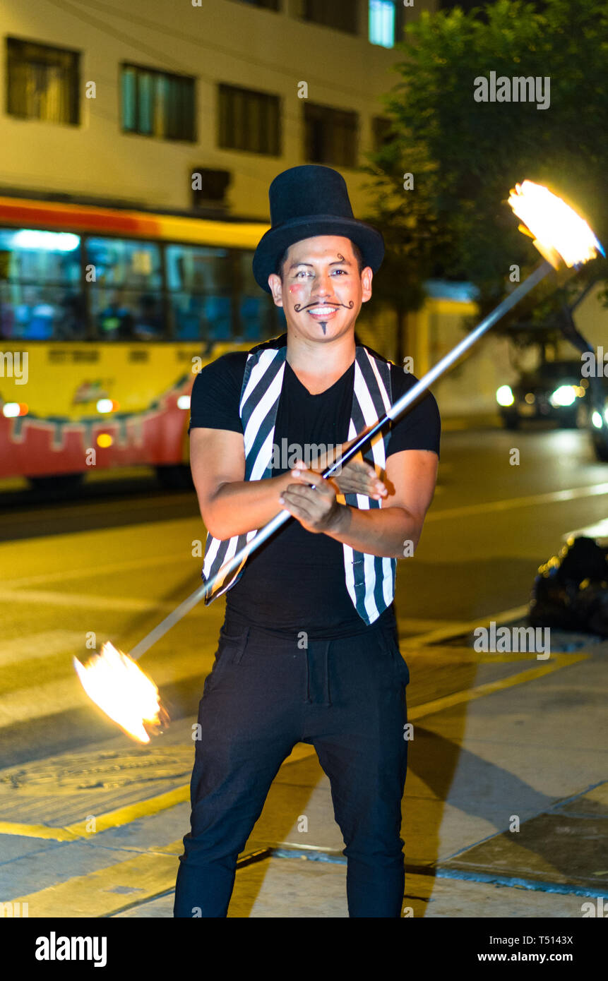 Eine Straße Künstler, macht eine Show in Lima - Peru, Jonglage ein Stick mit Feuer an einer Ampel, vor gestoppt Autos Stockfoto