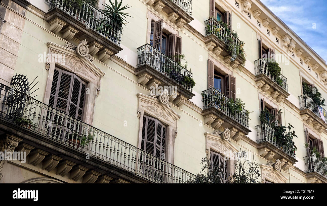 Fassade mit Fenstern und Balkons mit Pflanzen dekoriert Stockfoto