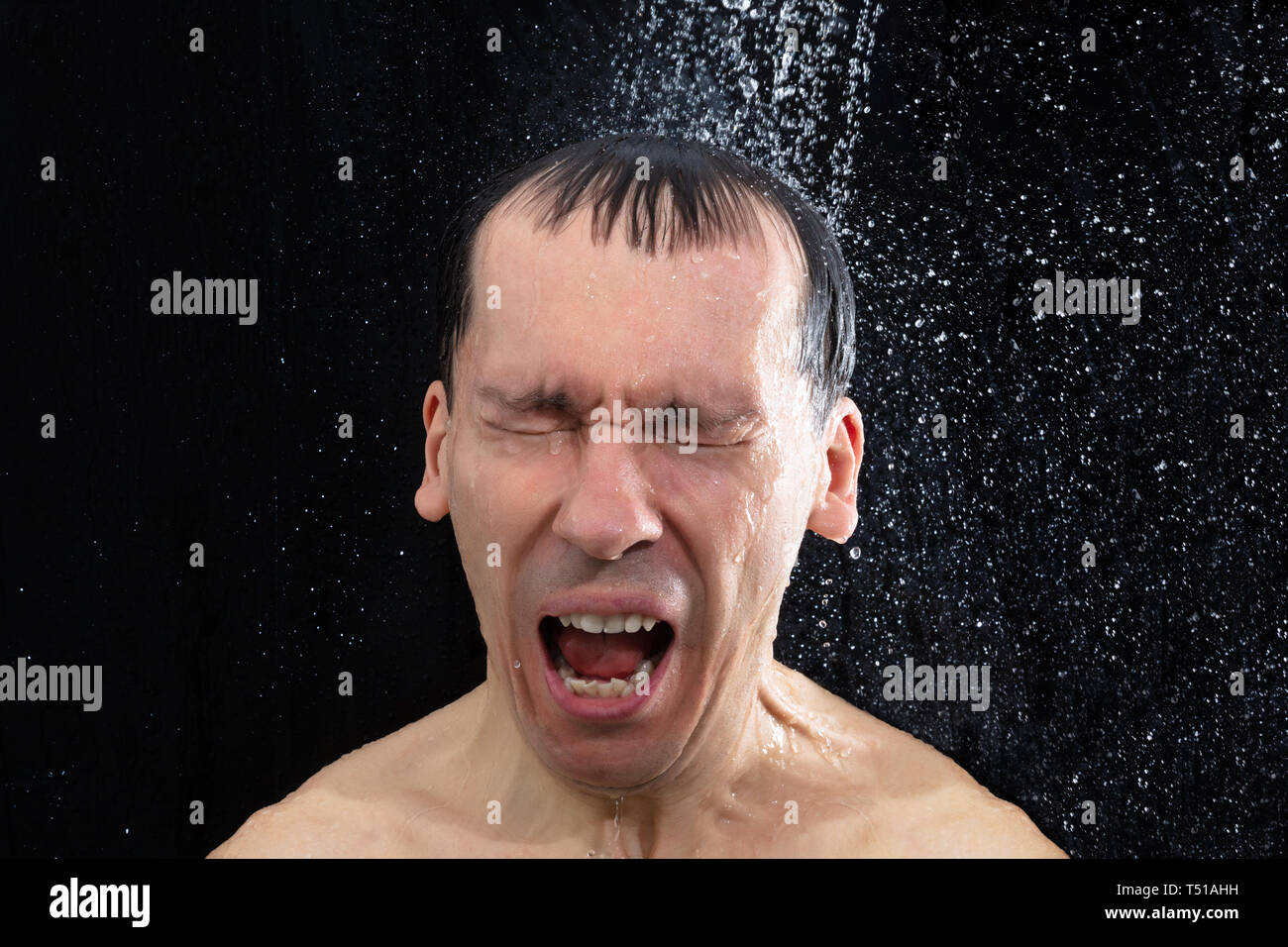 Portrait des jungen Mannes, die kalte Dusche im Badezimmer Stockfoto