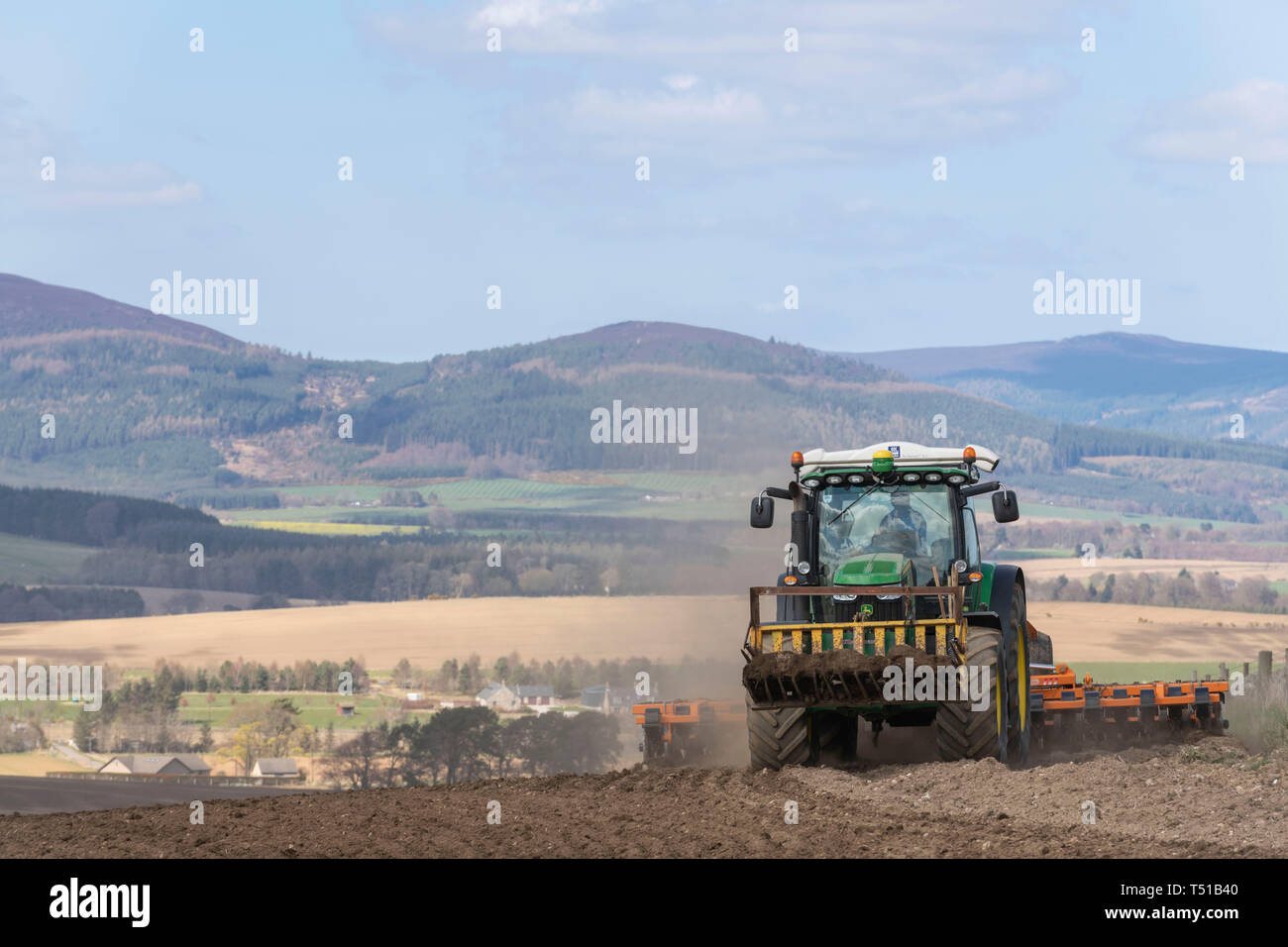 Ein Landwirt Eggen ein kürzlich in Aberdeenshire mit Pitfichie Hügel im Hintergrund Gepflügt Stockfoto