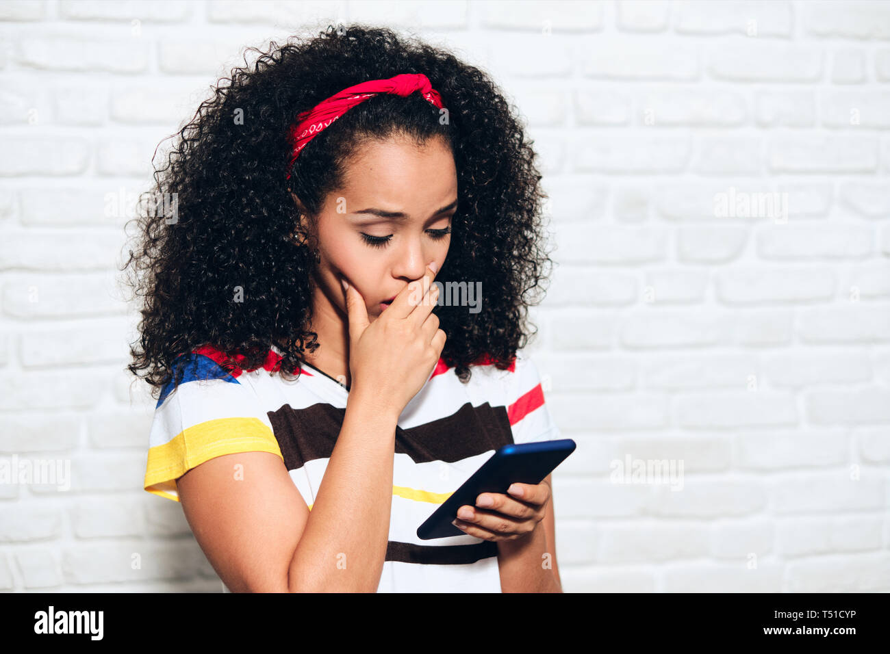Traurig african american woman reading schlechte Nachrichten auf Handy. Schwarzes Mädchen, Traurigkeit und Verzweiflung für Nachricht auf Mobiltelefon. Hispanische person Stockfoto