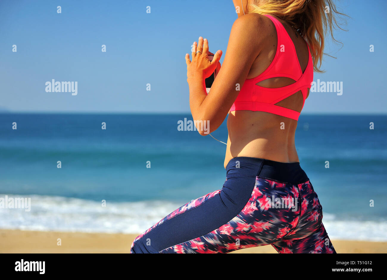 Genießen Sie die Küsten-Vibes: Jog on the Beach einer jungen Frau, die Sonne, Sand und die Ruhe der Natur genießen Stockfoto