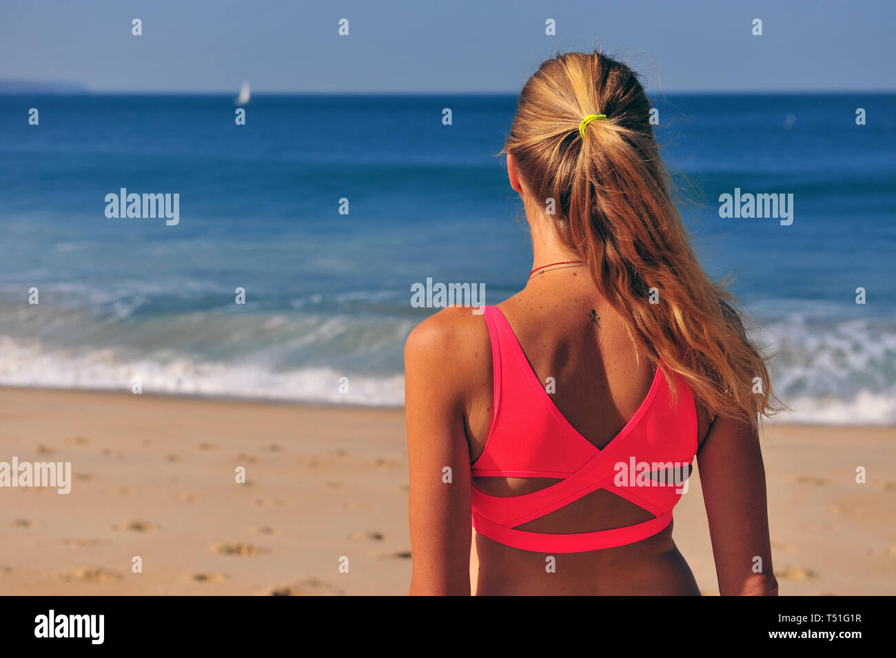 Genießen Sie die Küsten-Vibes: Jog on the Beach einer jungen Frau, die Sonne, Sand und die Ruhe der Natur genießen Stockfoto