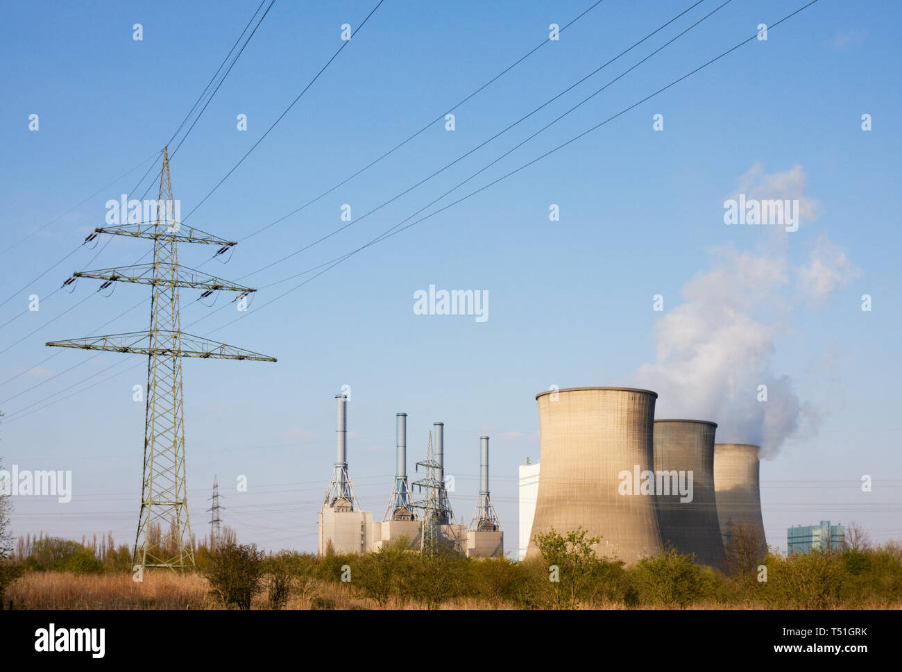 Ein Kohlekraftwerk und Stromleitungen in der Natur. Stockfoto