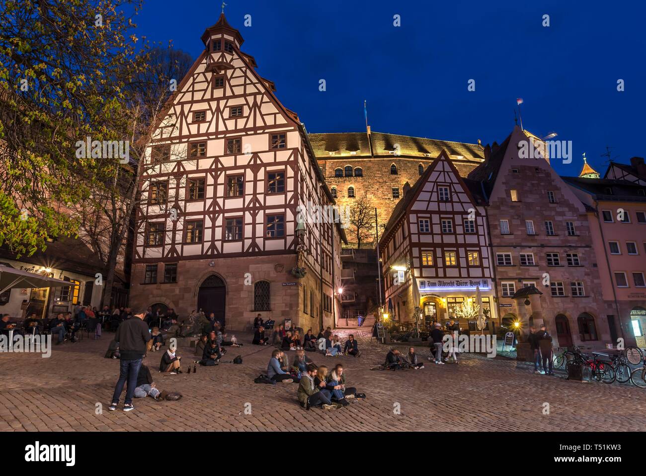 Lebendigen Platz mit jungen Menschen, historische Fachwerkhäuser mit der Nürnberger Burg am Abend, Nürnberg, Mittelfranken, Bayern, Deutschland Stockfoto