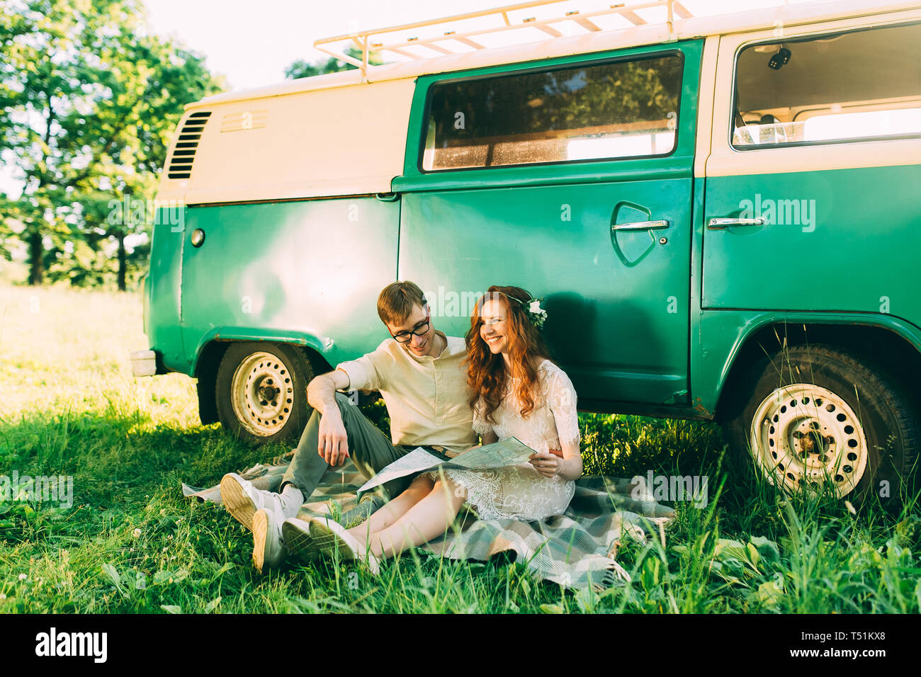 Jungen und Mädchen im Freien Studium eine Karte stützte sich auf einen Jahrgang grünen Bus Stockfoto