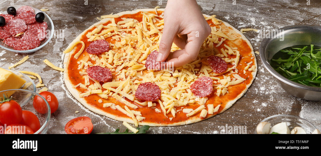 Koch Salami, italienische Pizza am Küchentisch Stockfoto