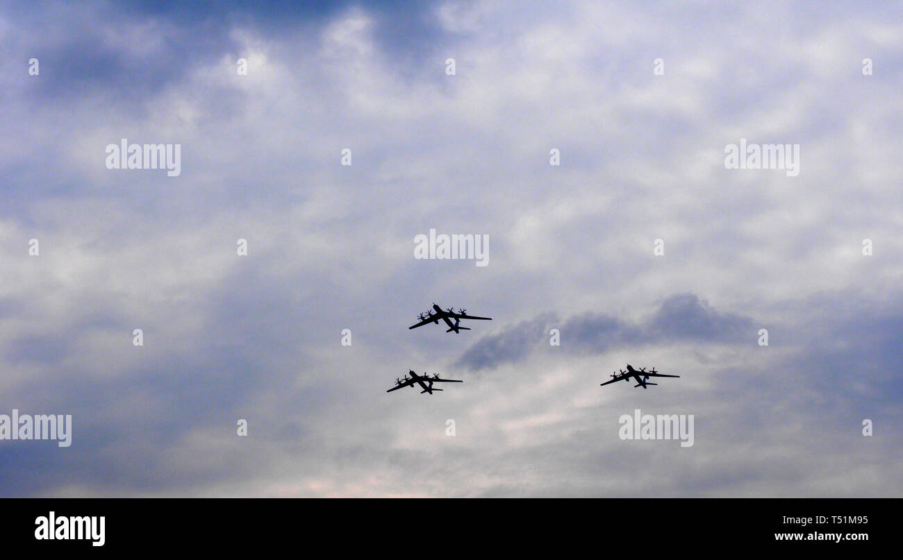 Silhouetten fliegen Russische Tu-95-Bomber gegen den Himmel. Militärische Parade. Stockfoto