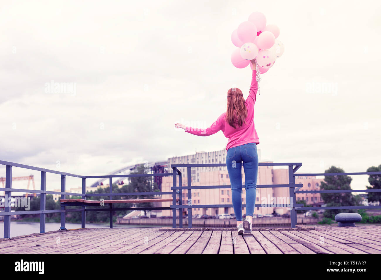 Skinny Ingwer Mädchen in rosa hell Hoodie holding Haufen Ballons Stockfoto