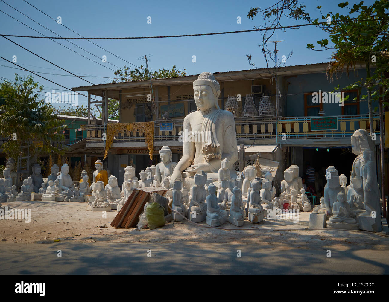 Eine Sammlung von halb fertige Skulpturen säumen die Straße, in der Steinbildhauerei Bezirk von Mandalay, Myanmar. Stockfoto