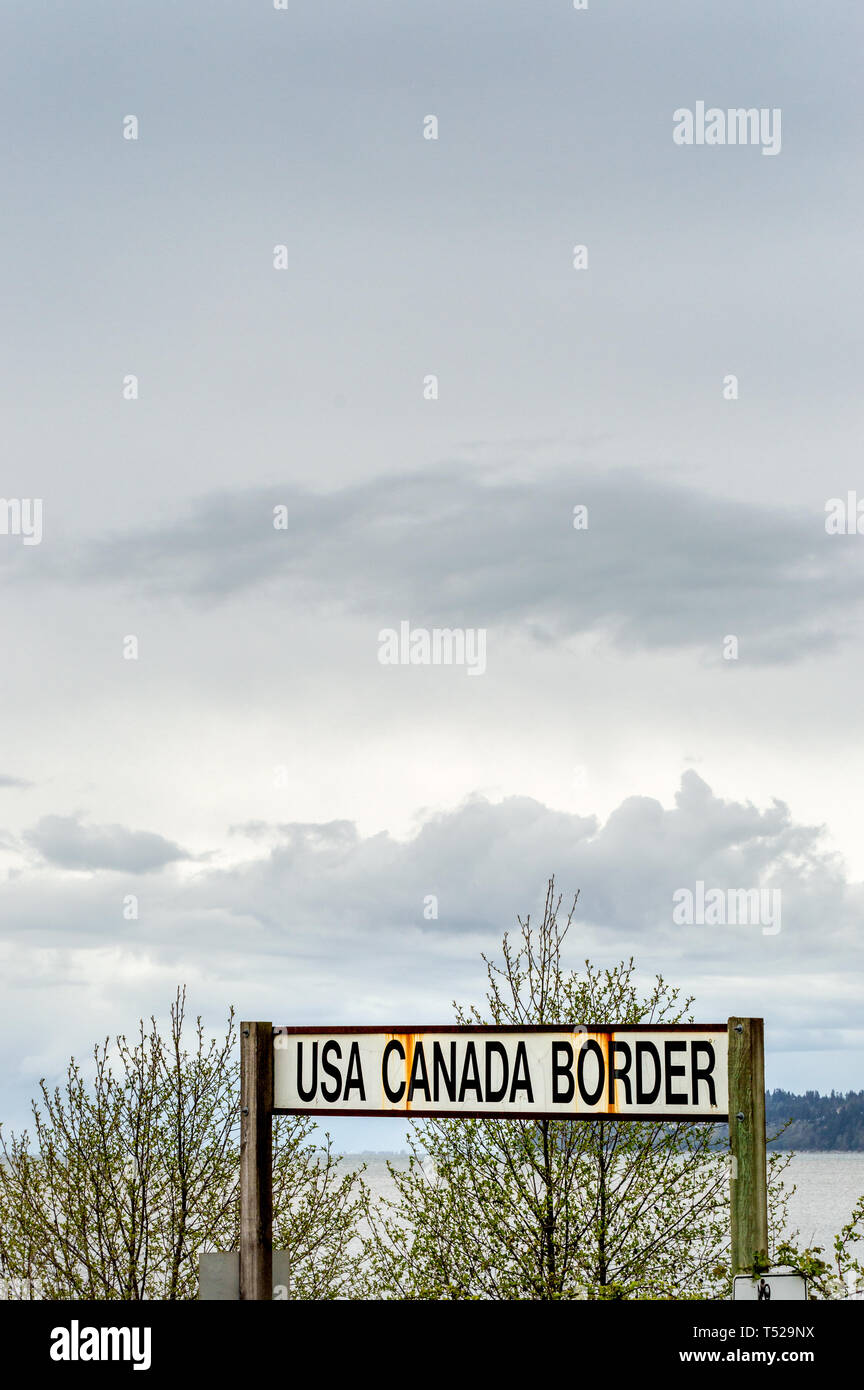April 14, 2019 - Surrey, British Columbia: BNRR Eisenbahn USA Canada Border unterzeichnen und Semiamoo Bay im Westen unter bedecktem Himmel. Stockfoto