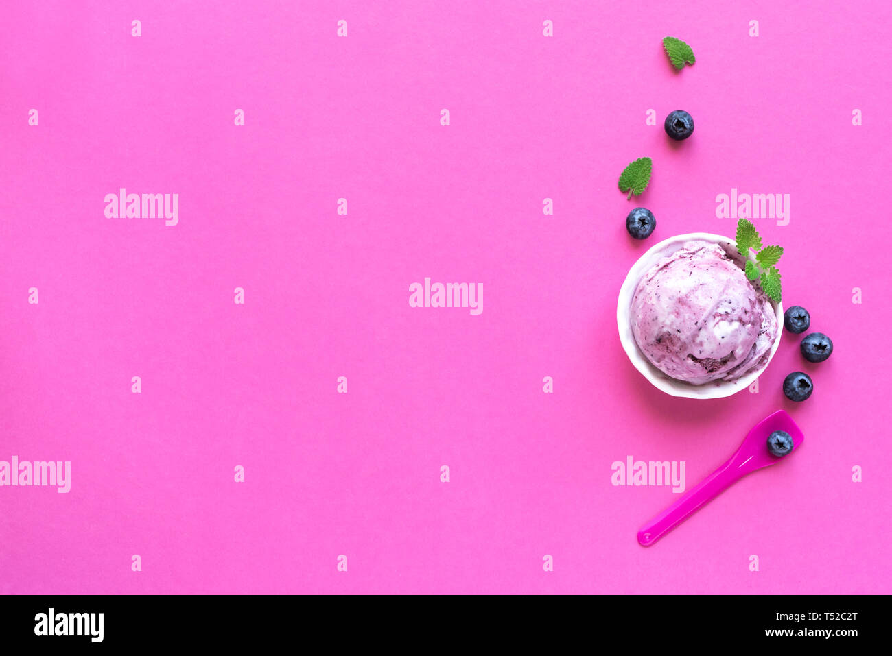 Heidelbeere Eis auf rosa Hintergrund, Ansicht von oben, kopieren. Kugel Gelato in Schale mit Blaubeeren und Minze. Stockfoto