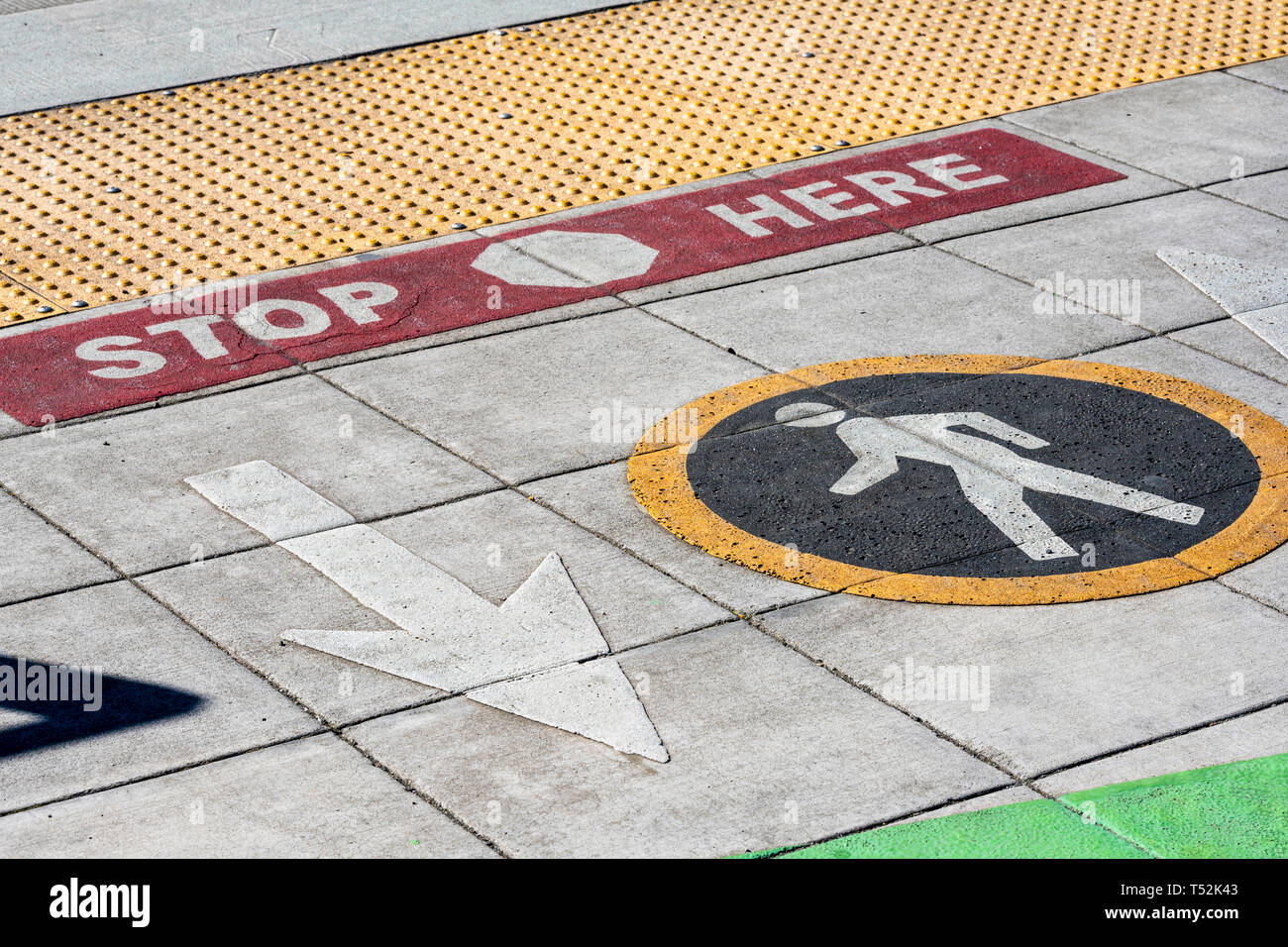 Farbe fahrbahnmarkierungen für Fußgänger an der Kreuzung zur Angabe der Richtung der Bewegung von Fußgängern, von rundem Schild angegeben, und eine sichere Sto Stockfoto