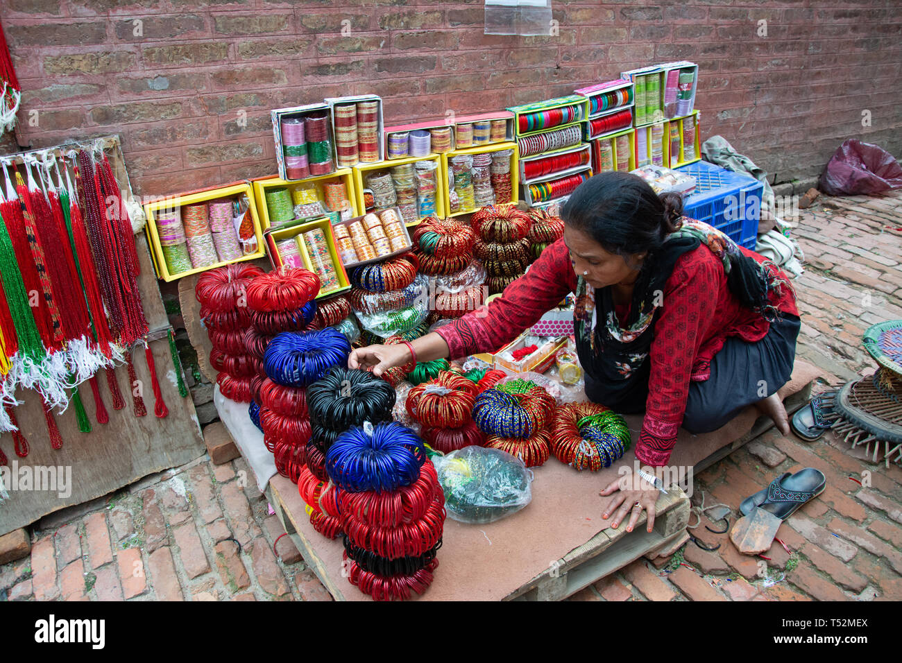 Kathmandu, Nepal - Mai 06, 2017: eine lokale Frau, die traditionelles Armreifen in der Straße am Bhaktapur. Stockfoto