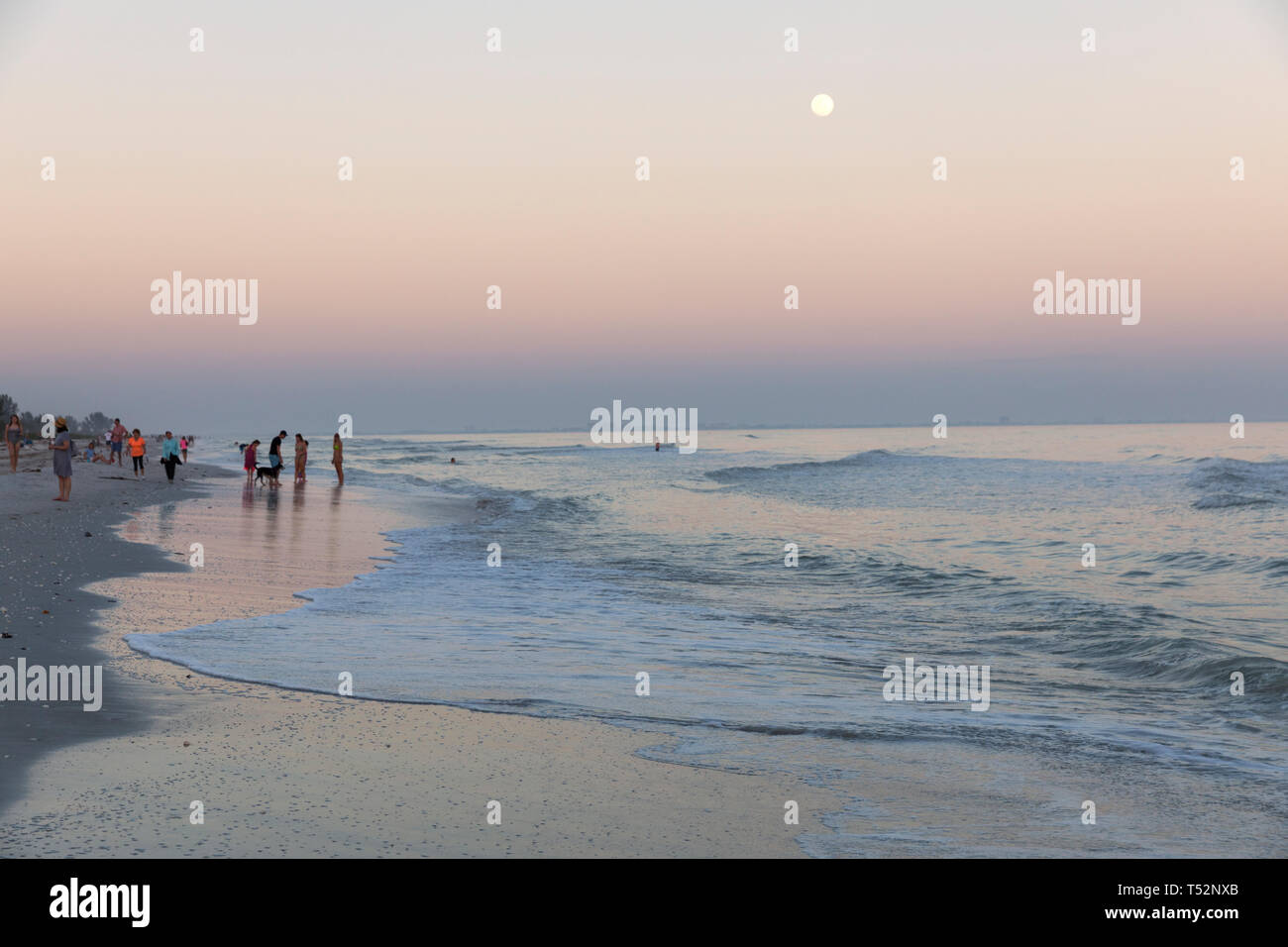 USA, Florida, Sanibel Island, den Golf von Mexiko, Strand mit Surf, Mondaufgang und Menschen Stockfoto
