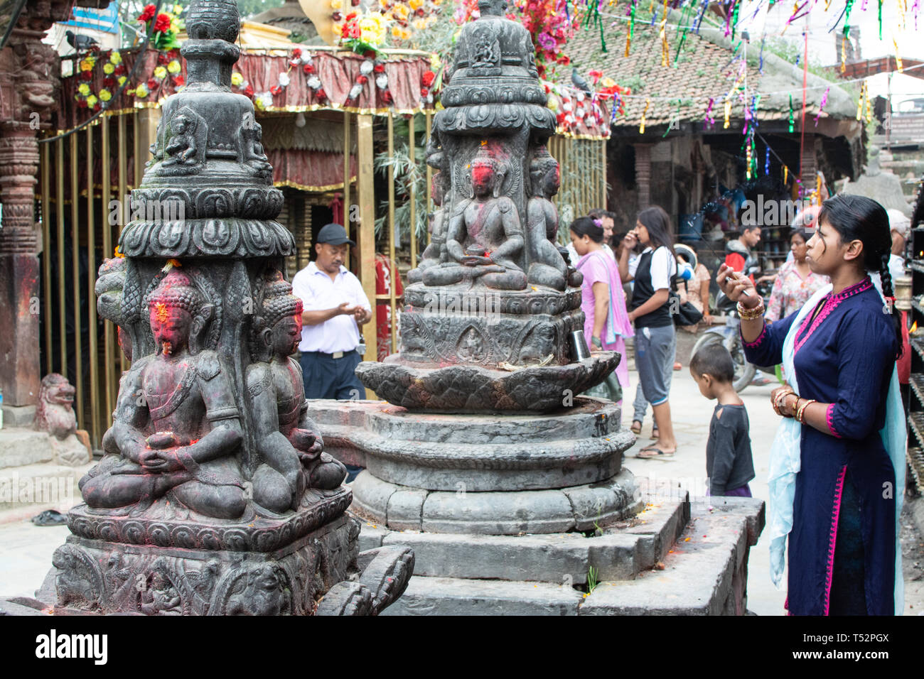 Kathmandu, Nepal - 27. August 2017: Unbekannte junge Frau in Freizeitkleidung Gebete durch das Verbrennen von Weihrauch in den Außenbereichen von Buddha Tempel. Stockfoto