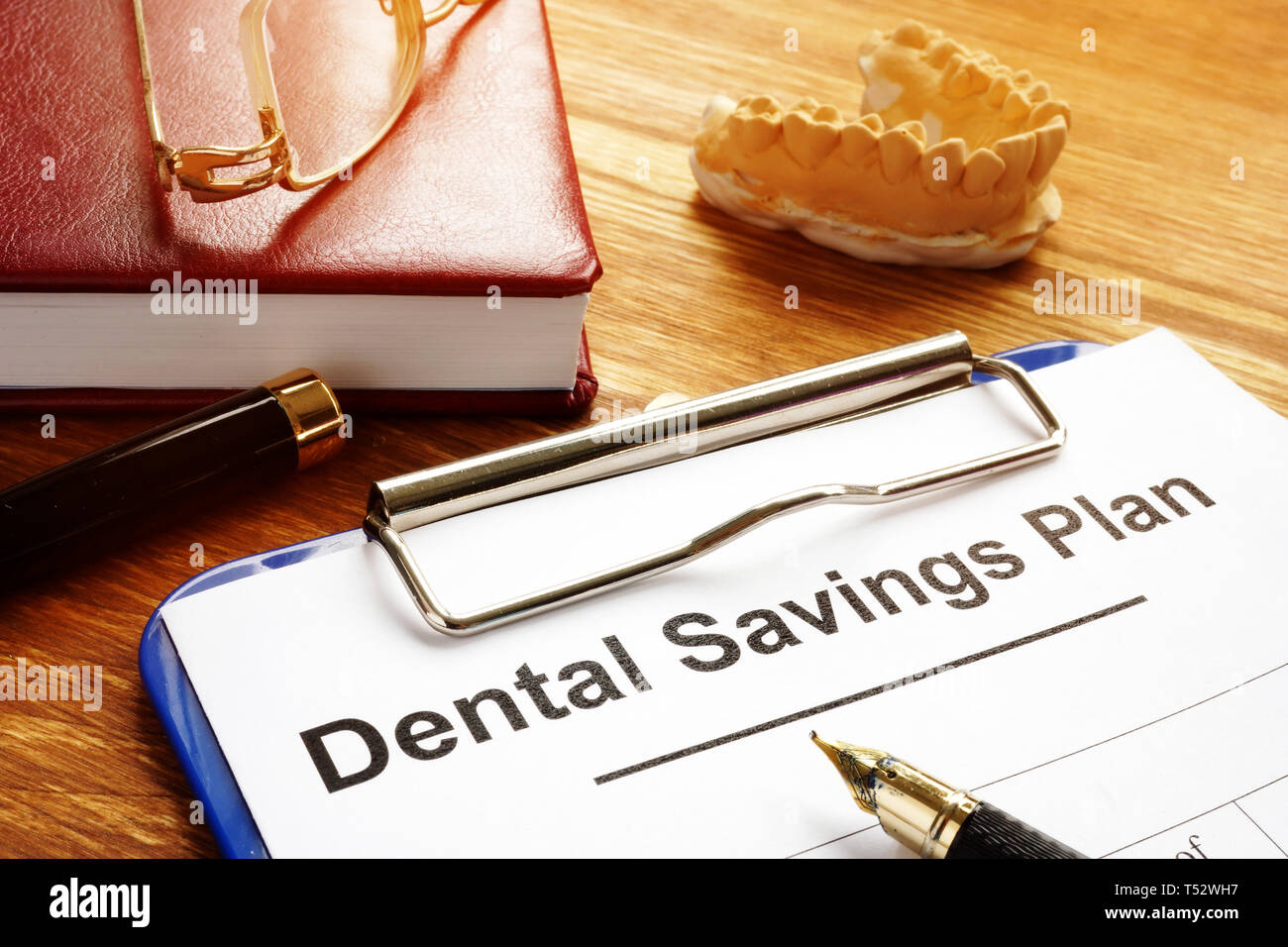 Zahnmedizinische Sparplan mit Zwischenablage auf dem Schreibtisch. Stockfoto