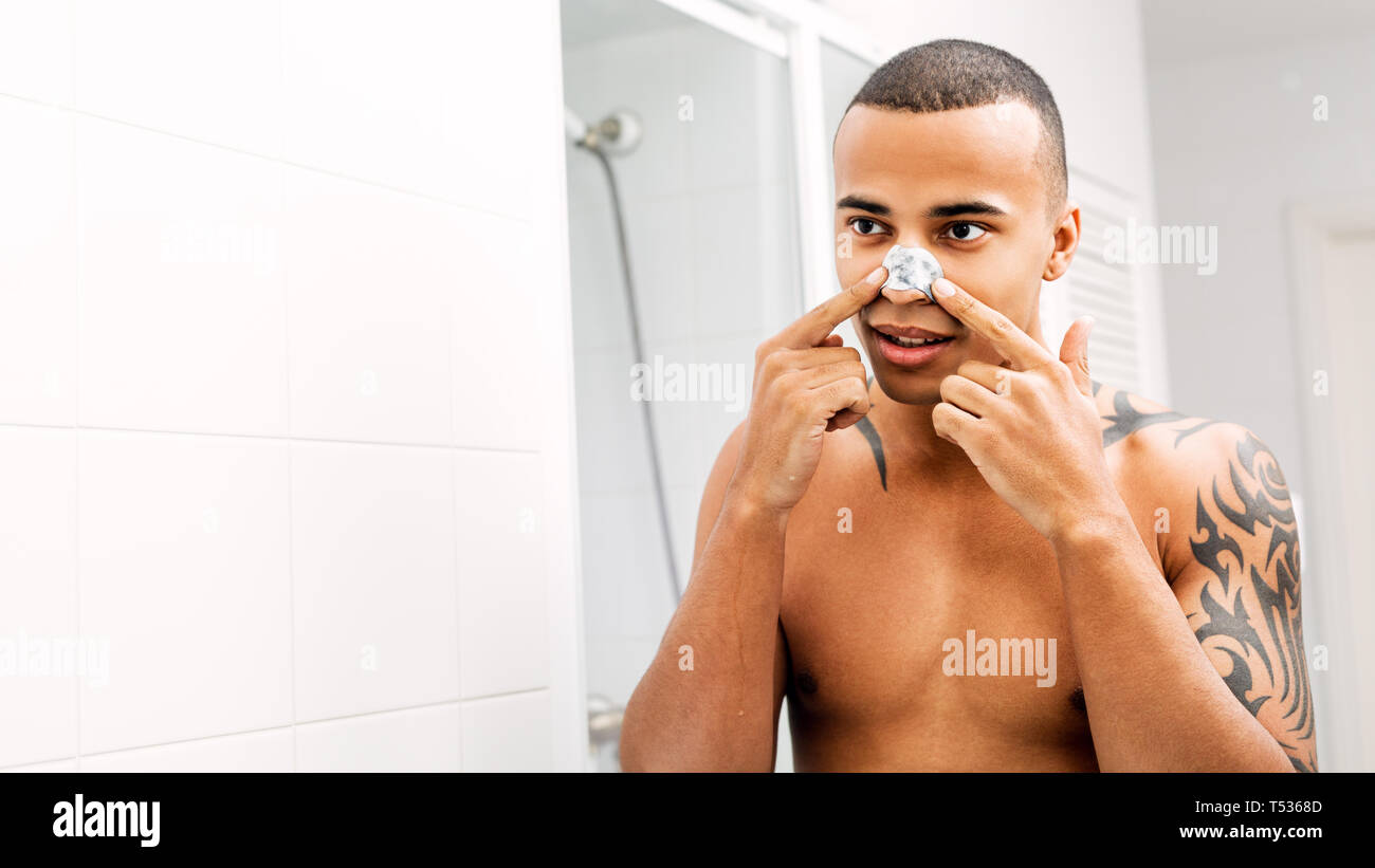 Junger Mann die Nase Patch vor einem Spiegel Stockfoto