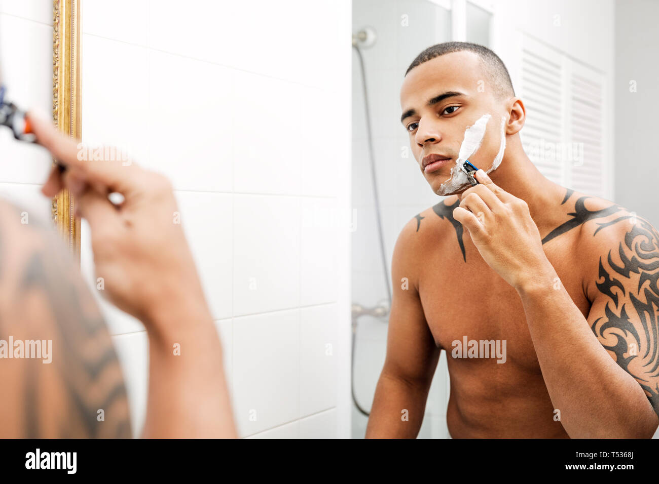 Porträt von einem gutaussehenden jungen Mann rasieren seine Haare im Bad Stockfoto