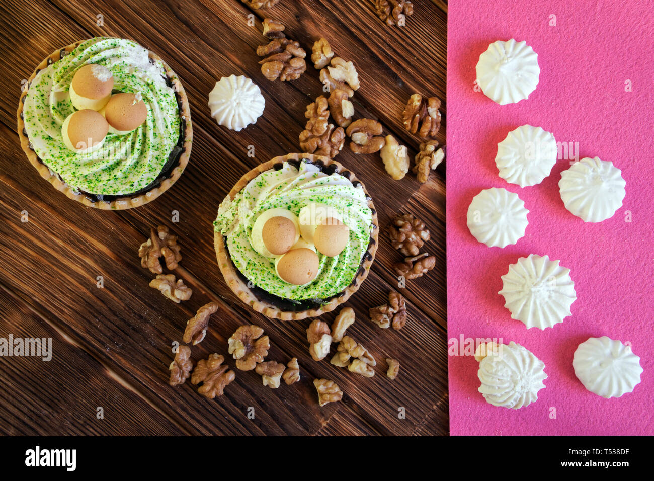 Kuchen in Form von einem Korb mit Pilzen, Walnüsse und Baisers auf dem Tisch der Kiefer Dielen geschält. Natürliche braun und rosa Hintergrund. Anzeigen von ab Stockfoto