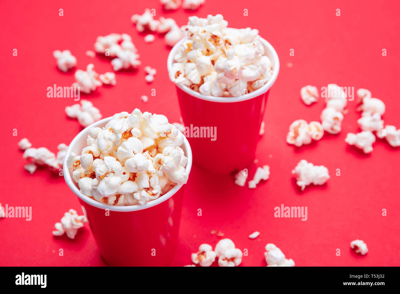 Frische salzige Popcorn in zwei roten Karton Container, rote Farbe Hintergrund, Detailansicht Stockfoto
